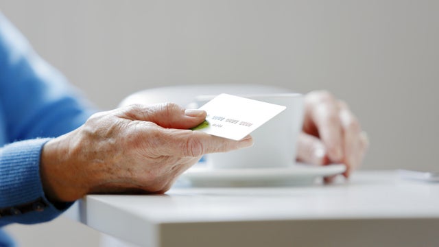 Mature hand holding a credit card 