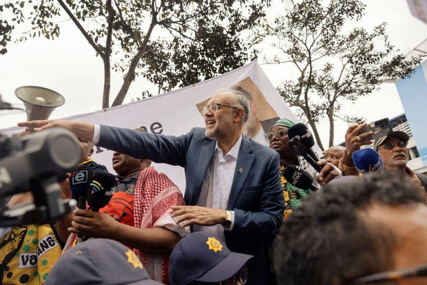 Former South African Ambassador to the United States Ebrahim Rasool (c), gestures ahead of addressing his supporters upon his arrival at the Cape Town International airport