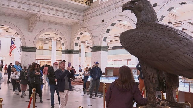 People take photos of the eagle statue at the Macy's in Center City Philadelphia 