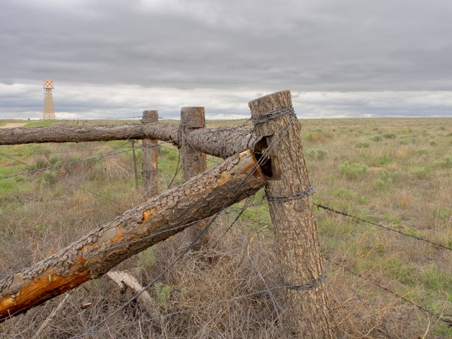 Rustic fence and barbed wire at edge of Amache Internment camp and pasture land 