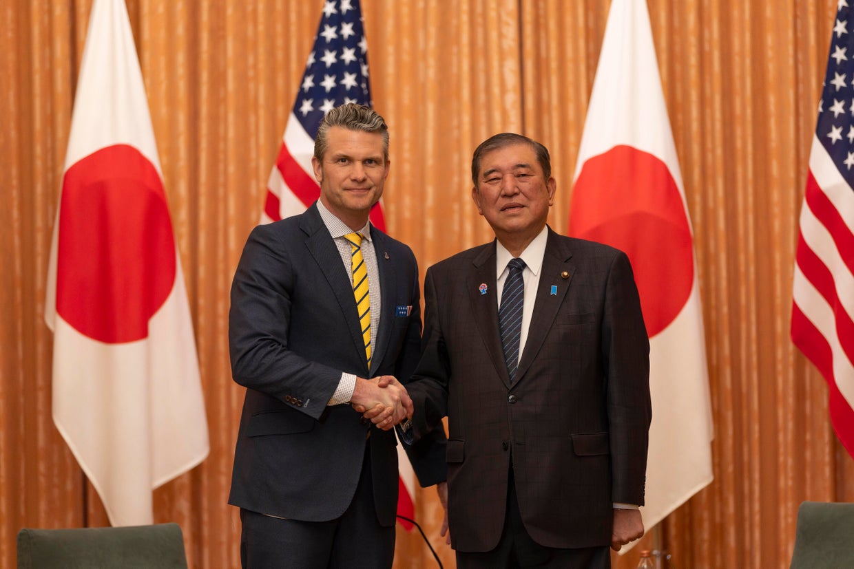 US Secretary of Defense Pete Hegseth (L) shakes hands with