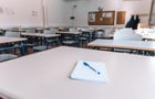 Notebook with a pen on a table in a classroom at a school 