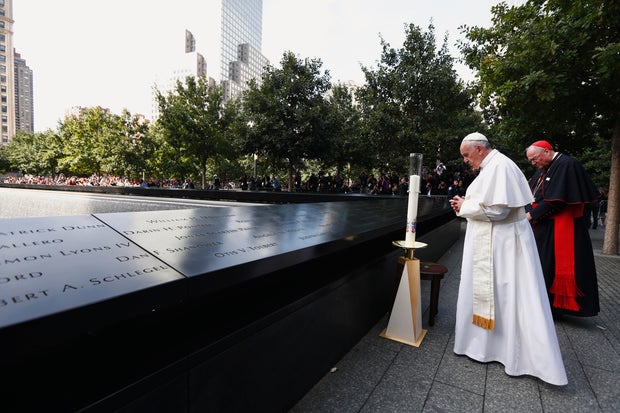 Pope Francis pauses in front of a candle to pray with Cardinal Timothy Dolan while visiting the 9/11 Memorial and Museum on September 25, 2015 in New York City. 