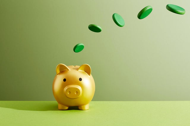 Coins flying into a piggy bank 