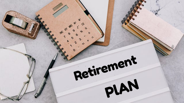 directy above workspace with laptop and office supplies.Retirement plan reminder 
