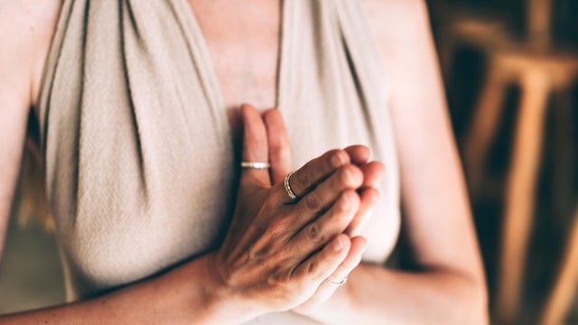 Close-up of woman's hands in prayer pose symbolizing inner peace 