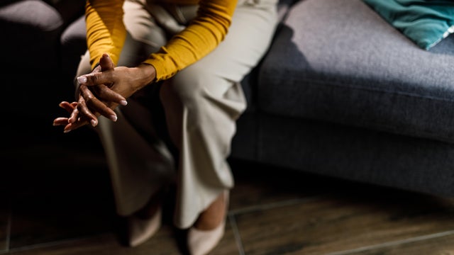 Woman anxiously fidgeting her hands while struggling with negative emotions 