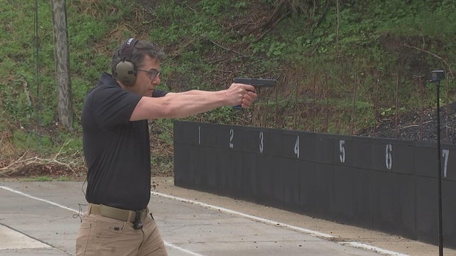 An officer shoots a gun at a gun range 