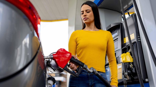 Customer refueling her car at a gas station 
