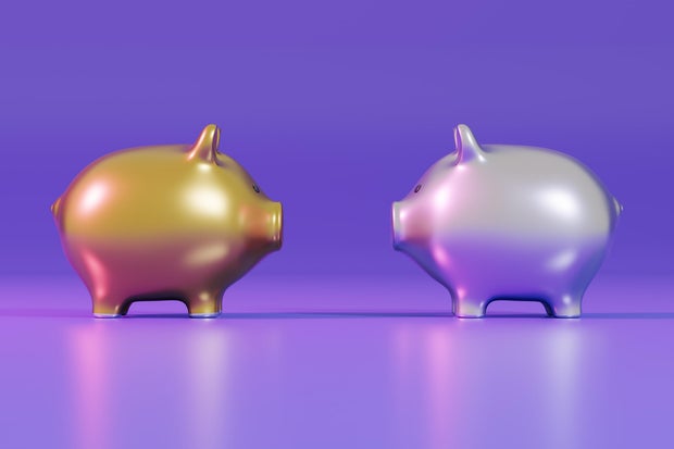 Gold and silver pig banks face each other 