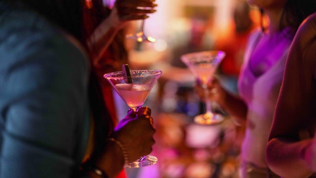 Close Up of A Martini Glass Held By A Female At A Bar 