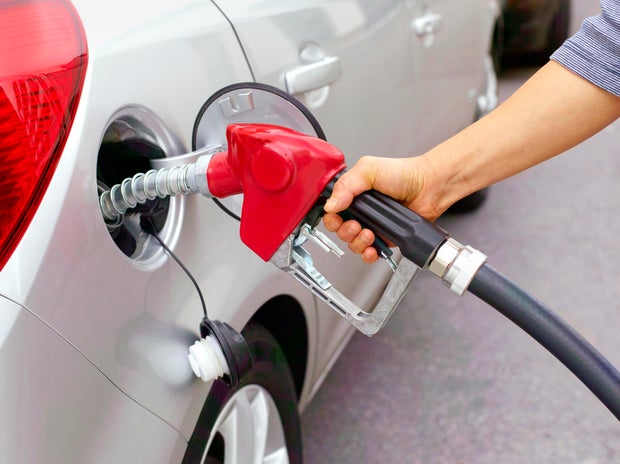 Woman filling car with leaded fuel. 