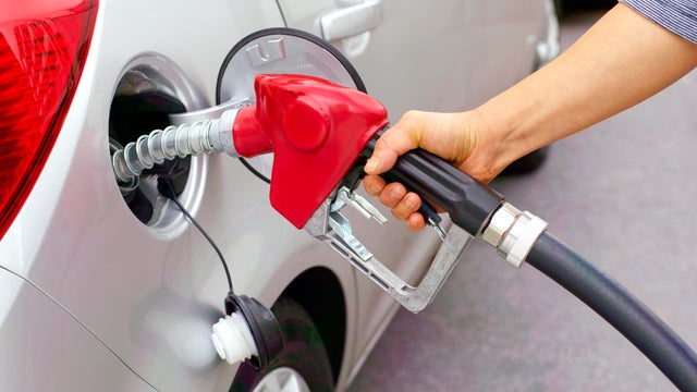 Woman filling car with leaded fuel. 