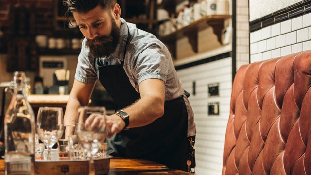 Waiter clearing table in restaurant 