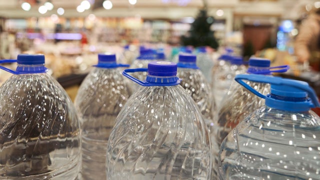 Plastic bottles of water in the shop, background with copy space. 