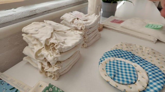 A stack of cloth diapers and other baby products on a table 