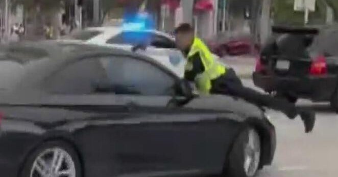 Cellphone video captures Miami officer firing at driver on hood of moving car near Bayfront Park Cellphone video captures Miami officer firing at driver on hood of moving car near Bayfront Park