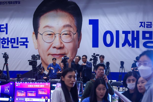 Journalists gather inside the situation room for Democratic Party presidential candidate Lee Jae-myung, pictured on the poster, at the National Assembly, as voting in South Korea's presidential election comes to an end, in Seoul, June 3, 2025.