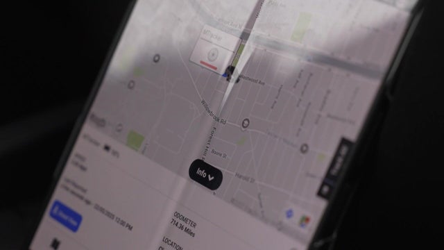 A screen displays a vehicle with a GPS tracker attached. 