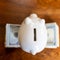 white piggy bank on top of stack of u.s. paper bills 