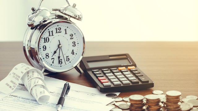Tax-filling concept .Tax form 1040 with pen, clock,coins and calculator on desk.Tax concept 