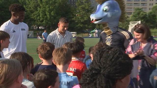 A photo from the soccer clinic, the Union mascot, Phang, and Union players talk to kids 