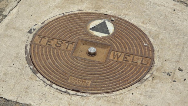 A well in the ground in Mt. Eyre neighborhood, it says "test well" 