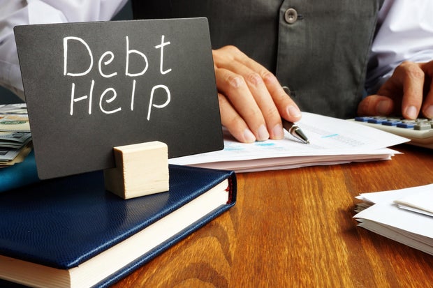 Debt help sign and working man in the office. 