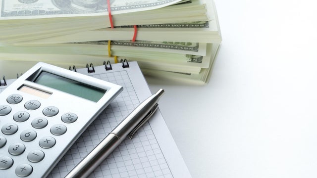 Calculator, Pen, Notepad And Dollar Bills. The concept of financial accounting, calculation of business profit or loss, management of expenses and income.  Investing, business and the global crisis. Lending and insurance. Salary, bribe or credit funds. 