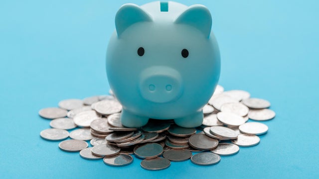 Piggy bank and coin on light blue background for money savings. Earning interest on savings. Growing your wealth and saving money concept 