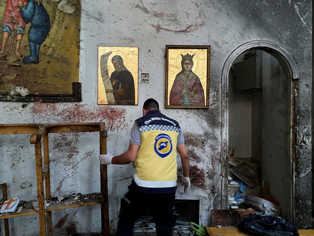 A member of the civil defense examines the damage after the explosion of the St. Elias Church in the Doyla neighborhood in Damascus 