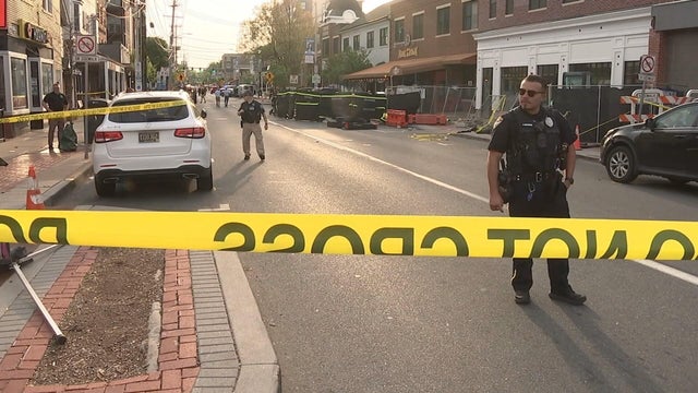 Caution tape and police officers are seen on the scene of the crash on Main Street in Newark, Delaware 
