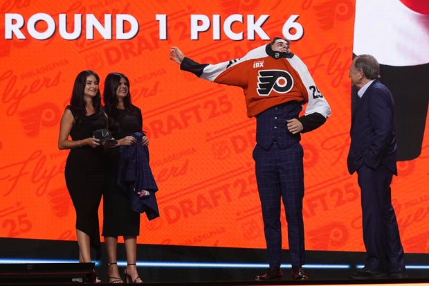 Porter Malone is on stage putting on a Flyers jersey during the draft 