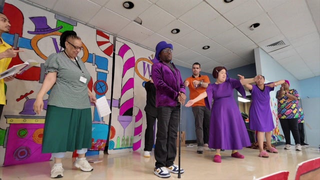 Performers with disabilities on stage for a production of "Willy Wonka." 