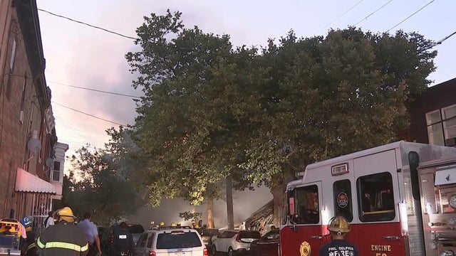 Firefighters and a firetruck are on the scene as smoke billows from the scene of an explosion in Nicetown, Philadelphia 