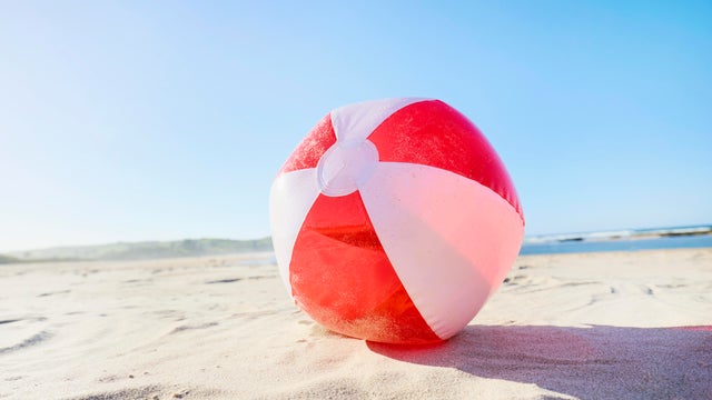 Inflatable ball at beach against blue sky 