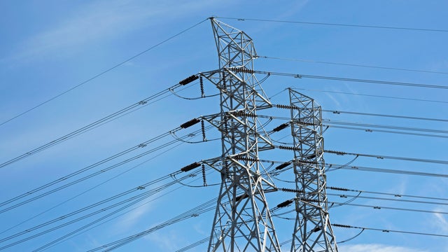 Electricity pylons tower power lines, blue sky 