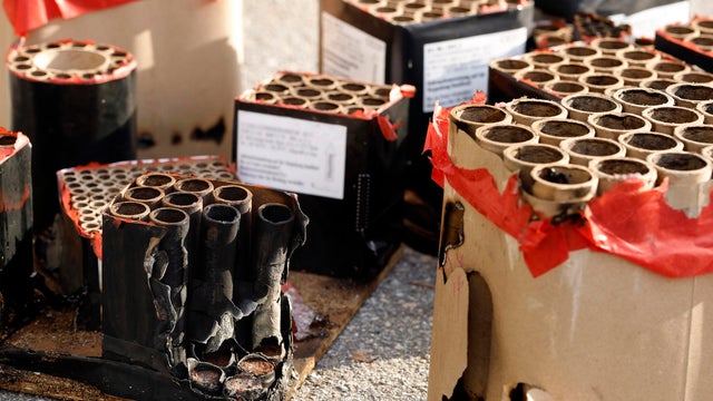 Batteries with fired fireworks on street in sunlight, trash from spent fireworks on New Year's Day, environmental impact from disposal costs and cleanup 
