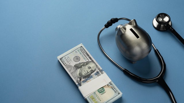 piggy bank with us dollar bills and stethoscope 