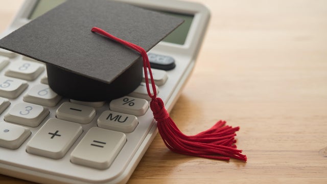 Mortarboard on white calculator. 