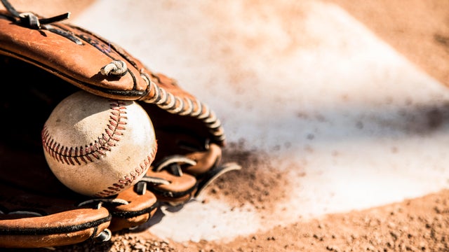 Baseball season is here.  Glove and ball on home plate. 