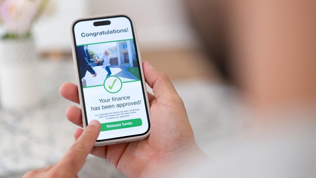 Man holding a digital with mortgage loan application approval. 