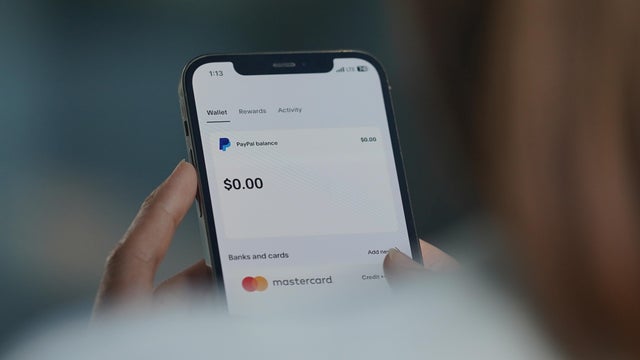 In this photo illustration, A woman browses the Paypal APP 