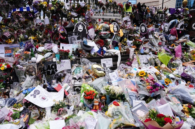 Floral tributes are left on the Black Sabbath Bridge bench July 28, 2025, on Broad Street in Birmingham, England, following the death of Black Sabbath frontman Ozzy Osbourne. 