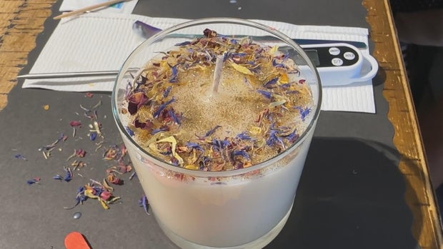 A custom candle at Wax N Scent studio, it has dried flower petals in the top 