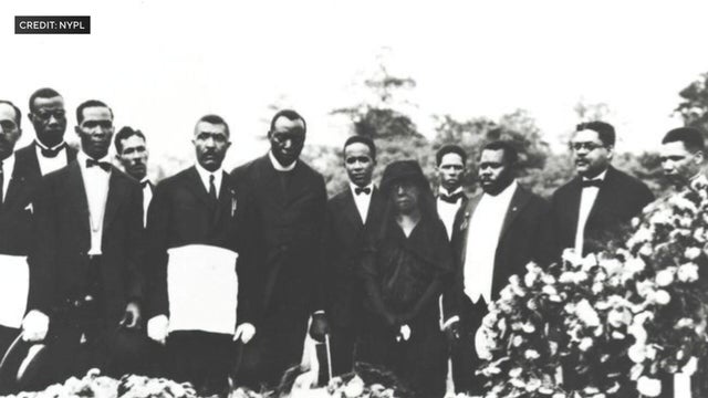 Mourners attend the burial of John Edward Bruce 