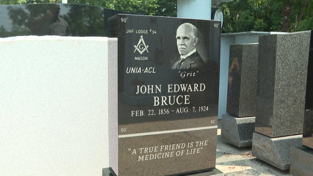 A black granite headstone for John Edward Bruce 
