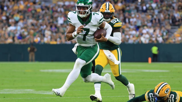 Justin Fields #7 of the New York Jets runs for a touchdown while chased by Keisean Nixon #25 of the Green Bay Packers during the NFL Preseason 2025 game at Lambeau Field on August 09, 2025 in Green Bay, Wisconsin. 
