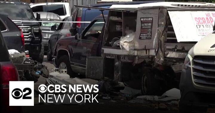 A heavily damaged food truck with its service window open sits among other vehicles in a lot. Debris is scattered on the ground and police tape is stretched across the scene. CBS News New York logo in corner.