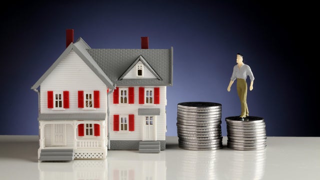 Model house and stack of coins-Concept of money saving 